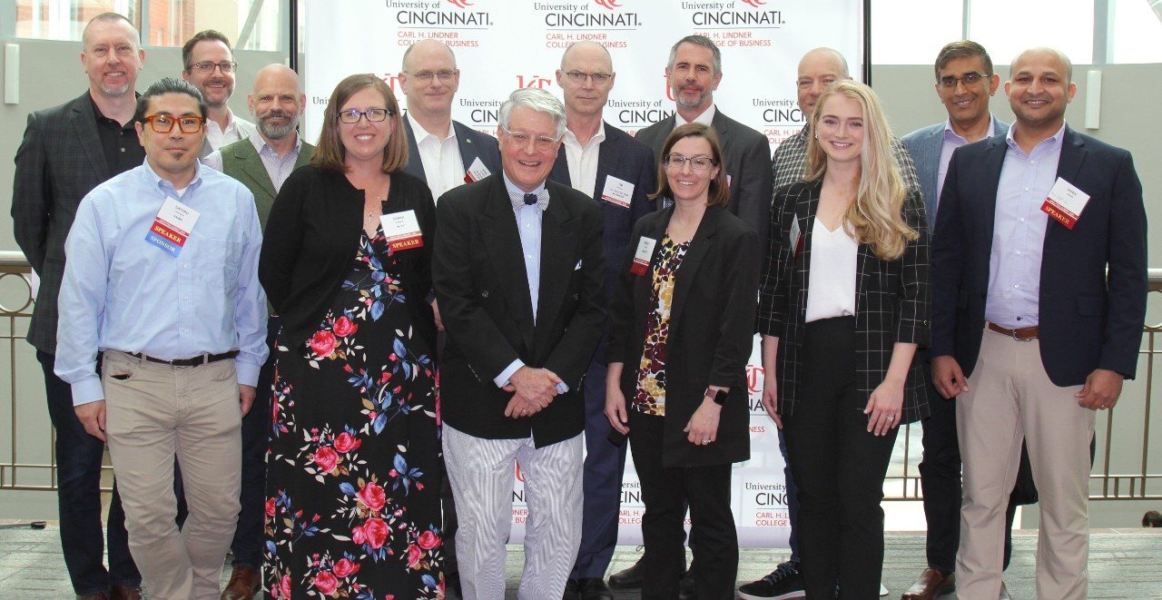 Men and women in professional dress pose for a group photo at the Analytics Summit.