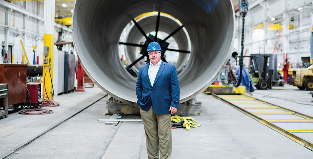 Scott Anderson standing on the Enerfab shop floor wearing a hard hat