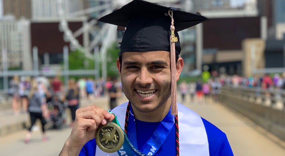 Aditya Roy-Chaudhury pictured in his graduation cap and cords after completing Cincinnati's annual Flying Pig Marathon