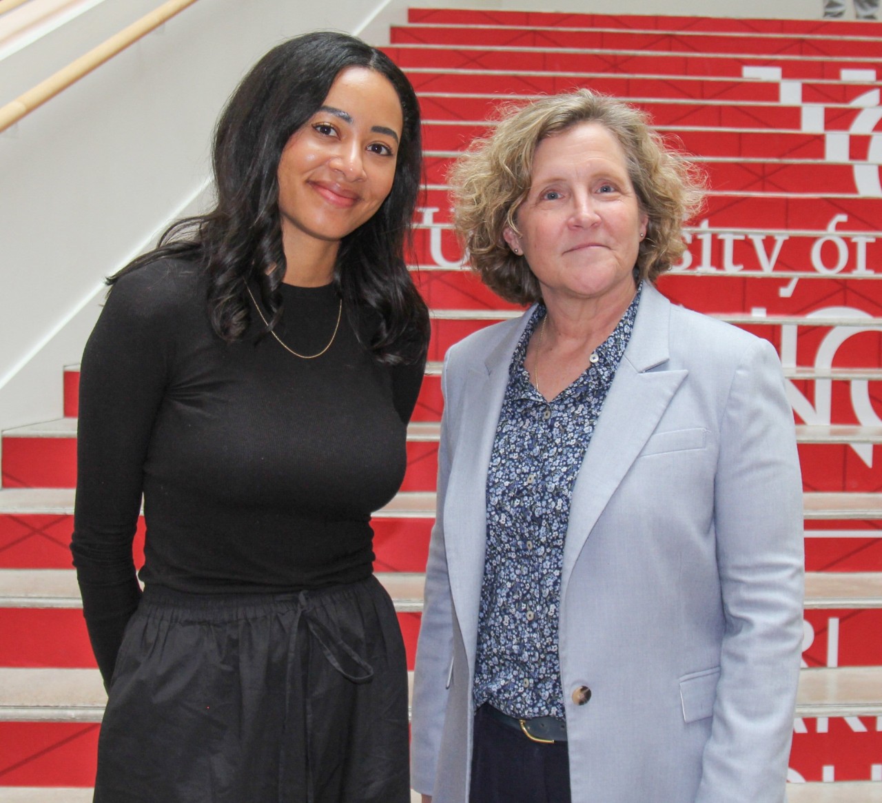 Janelle Wichmann stands in all black next to Dean Lewis in professional dress at Lindner Hall.