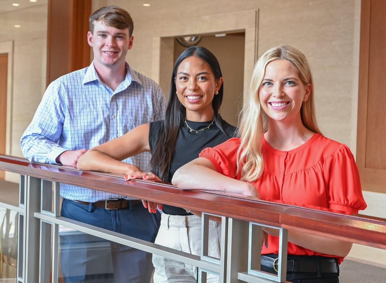 Two women and one man in various colors of professional dress.