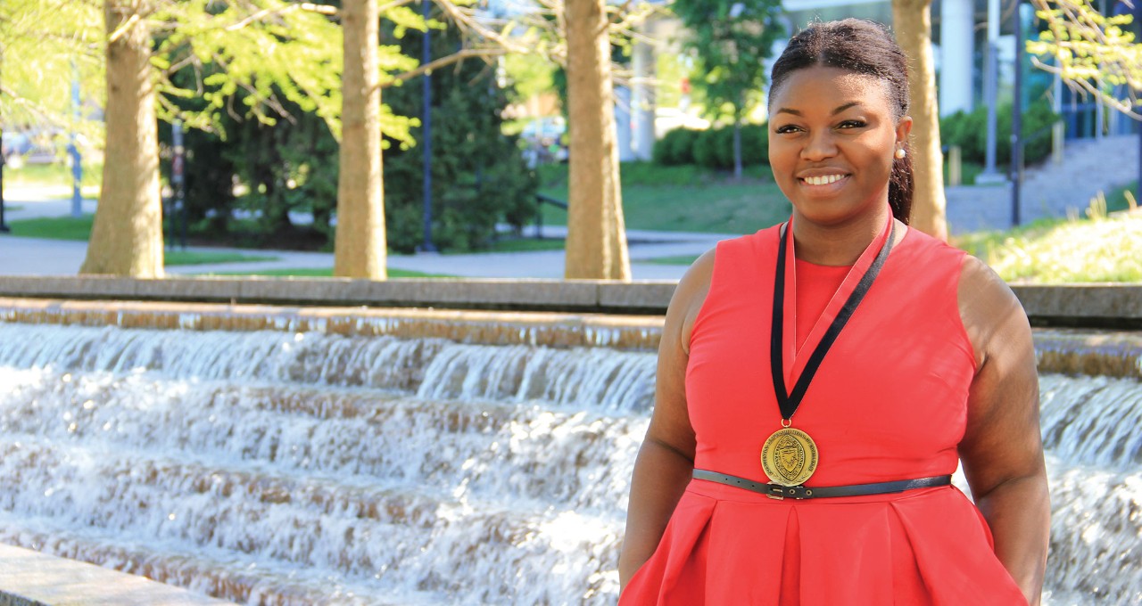 Gika Okonji wearing Presidential Leadership Medal in front of the fountain at Sigma Sigma Commons.