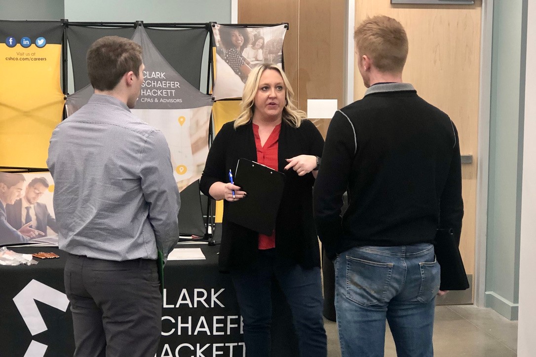 Recruiter talking with Lindner students at our branding table