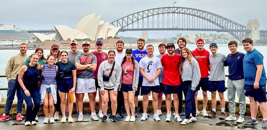 UC students standing in front of the Sydney Opera House and Sydney Harbor Bridge.