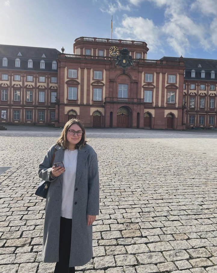 UC student standing in front of Mannheim University in Germany.